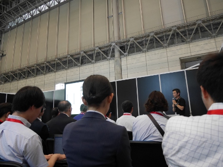 【Interop Tokyo 2014 パビリオンにて】当社のエンジニアの説明に熱心に聞き入るお客さま